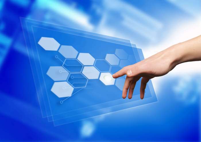 Hand touching a digital interface with hexagons