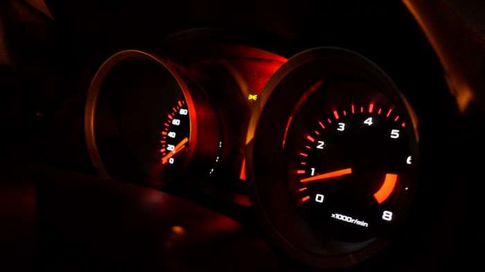 Car dashboard with illuminated gauges at night