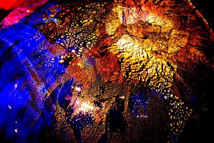 Abstract multicolor glass texture with blue, gold, and red.