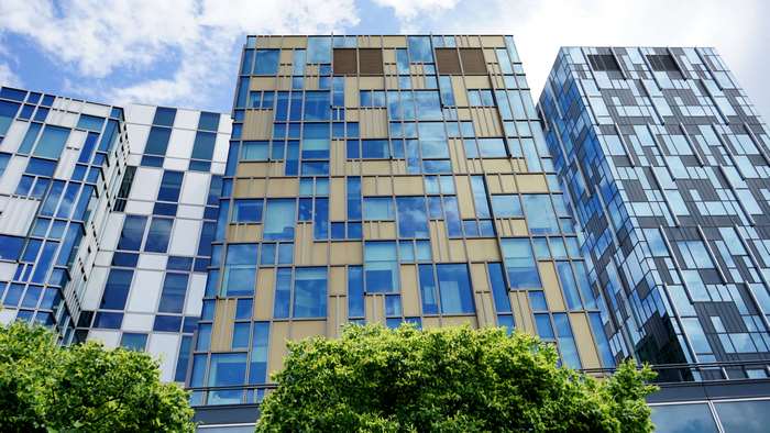 Modern glass buildings with blue sky and trees