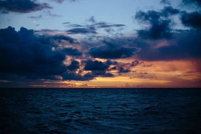 Ocean waves under a dramatic sunset sky