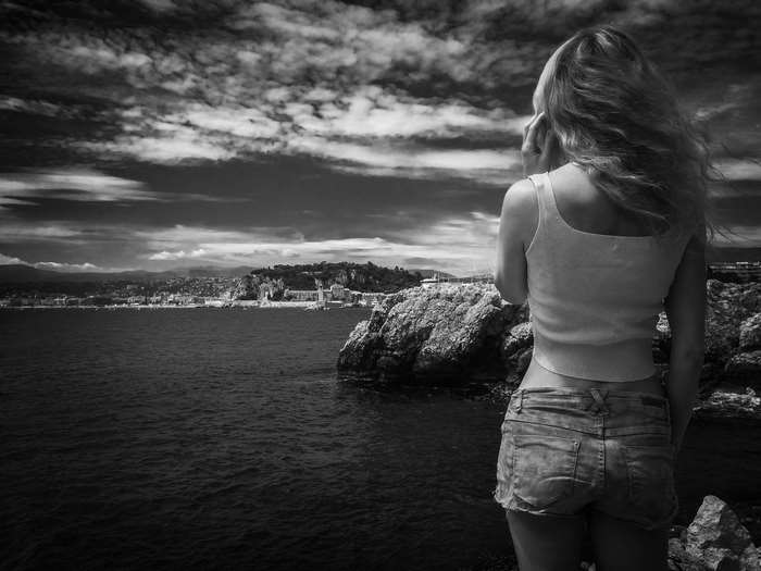 Woman in denim shorts looking at coastal city