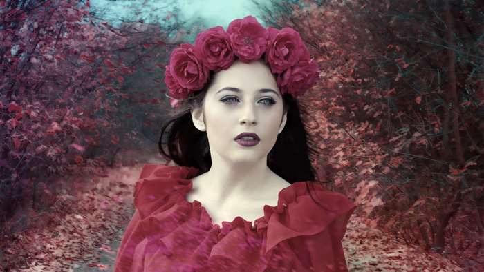 Fantasy woman with flower crown in autumn forest
