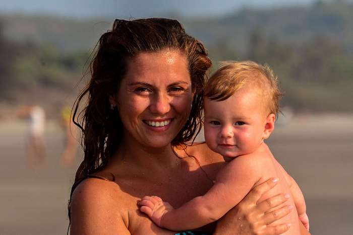 Mother holding her baby on the beach