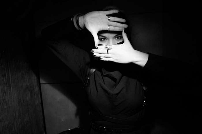 Woman framing face with hands, black and white