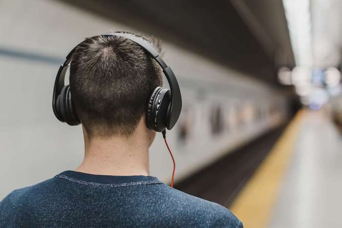 Man wearing headphones on a subway platform