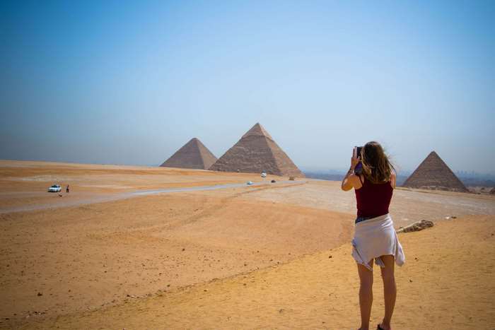 Woman photographing the Pyramids of Giza in Egypt
