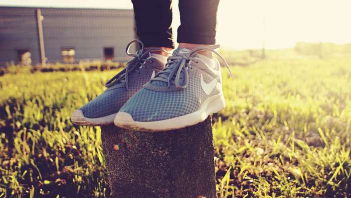 Nike running shoes on a post in grass