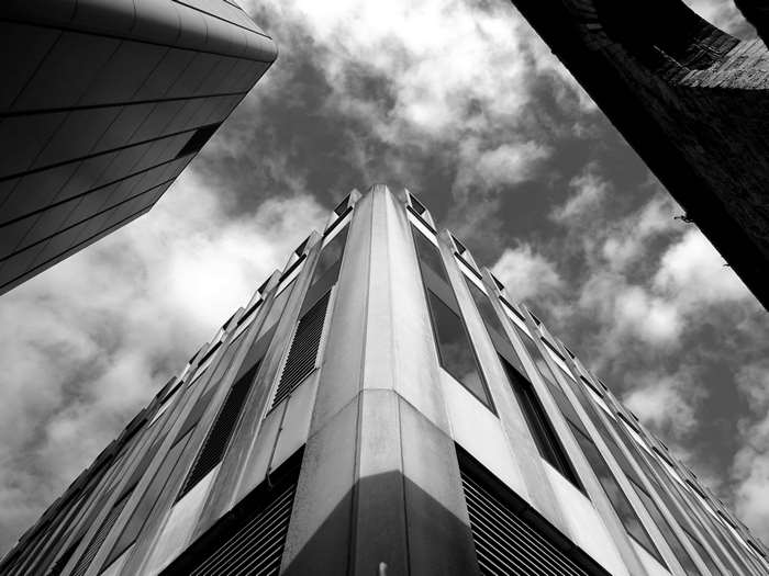 Low angle view of modern office buildings against a cloudy sky