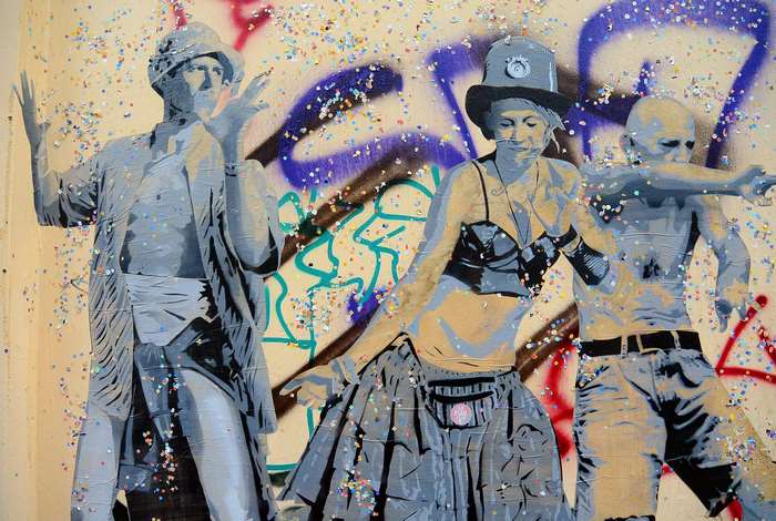 Graffiti art of three people dancing with confetti