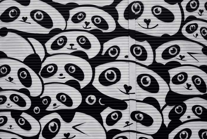 Graffiti art of many pandas on a roller shutter