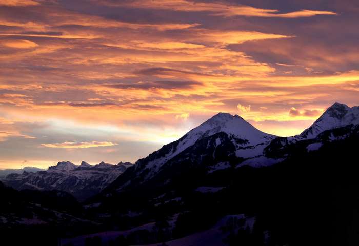 Snowy mountains at sunset with colorful clouds