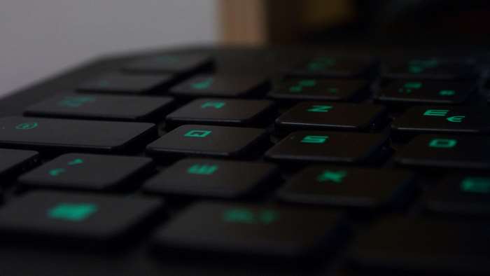 Close-up of a black gaming keyboard with green backlighting