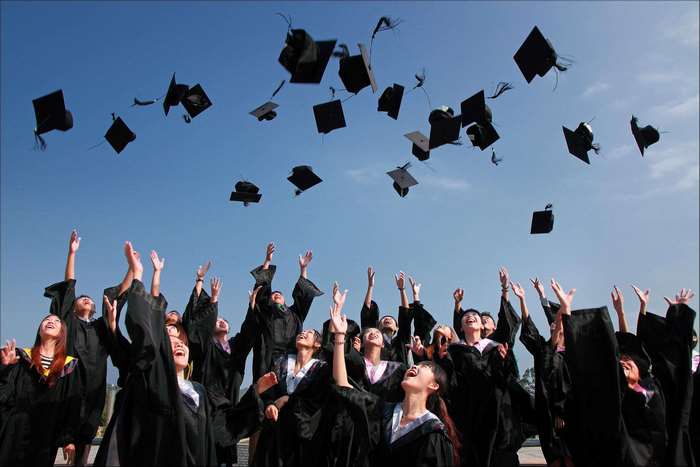 Graduation ceremony with students throwing caps in the air