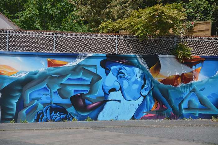 Graffiti art of a blue-skinned sailor smoking a pipe