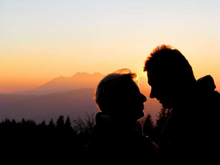 Couple silhouetted against a mountain sunset