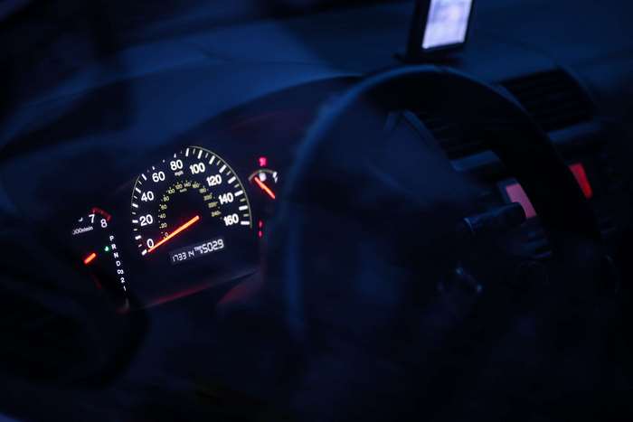Car dashboard with speedometer and odometer at night