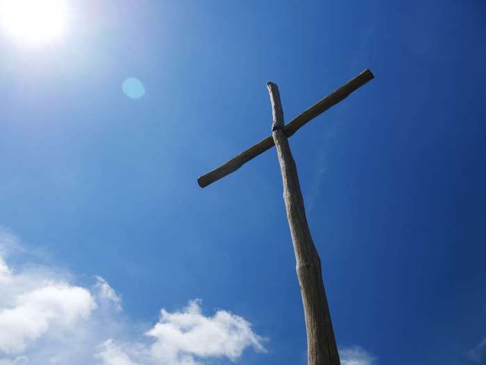 Wooden cross against a bright blue sky