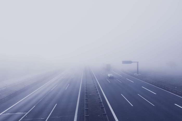 Foggy highway with cars and truck
