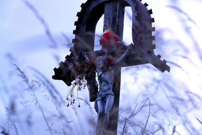 Jesus Christ on a wooden cross with flowers