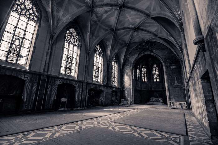 Dilapidated church interior with stained glass windows