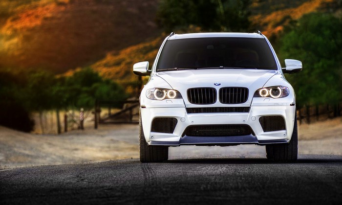 White BMW X5M front view on a road