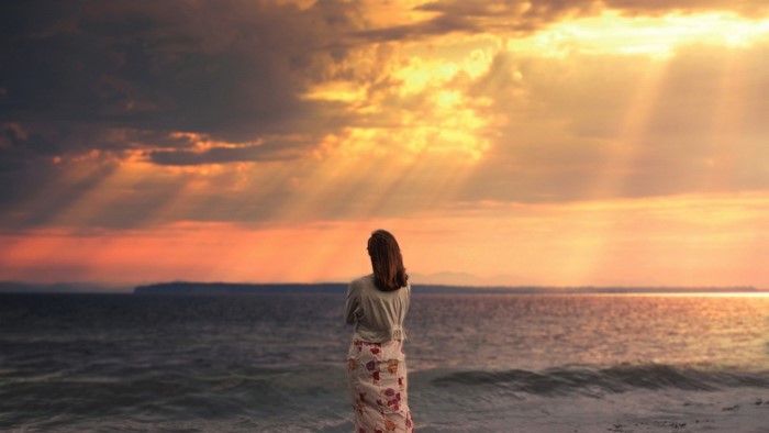 Girl watching sunset over the sea