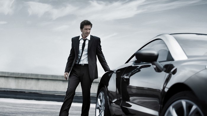 Man in Suit Standing Next to a Car
