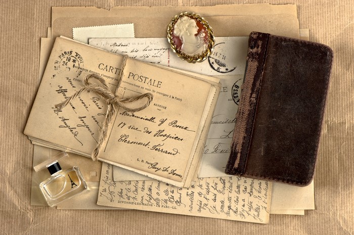 Vintage postcards, cameo brooch, perfume bottle, and notebook
