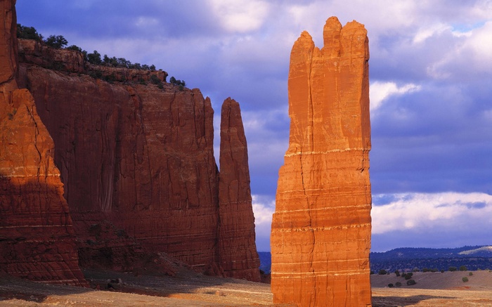 Red rock formations under a cloudy blue sky