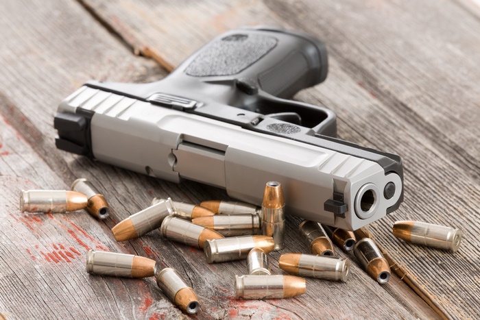 Pistol and bullets on a wooden surface