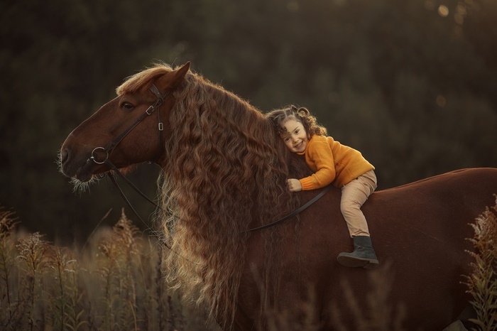 Girl riding a horse with long mane