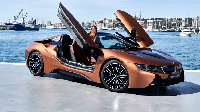 Orange BMW i8 Roadster parked by the water