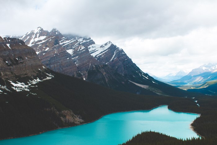 Turquoise lake and snow-capped mountains under cloudy sky