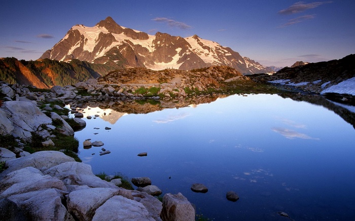 Snow-capped mountains reflected in a calm lake