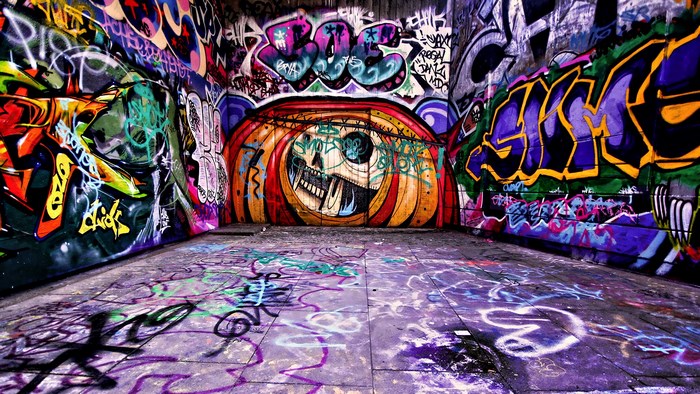 Graffiti-covered urban tunnel with skull mural