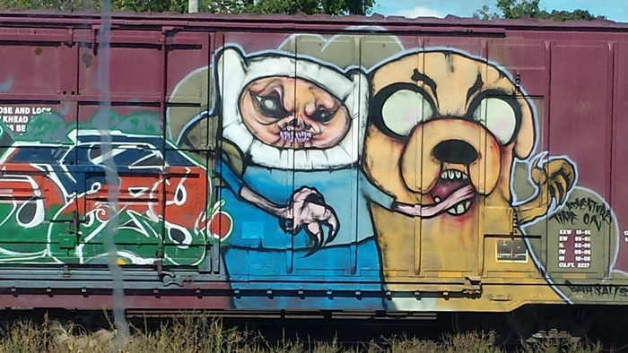 Finn and Jake from Adventure Time graffiti on a train car