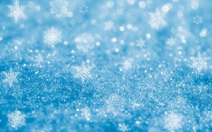Snowflakes falling on a blue glittery surface