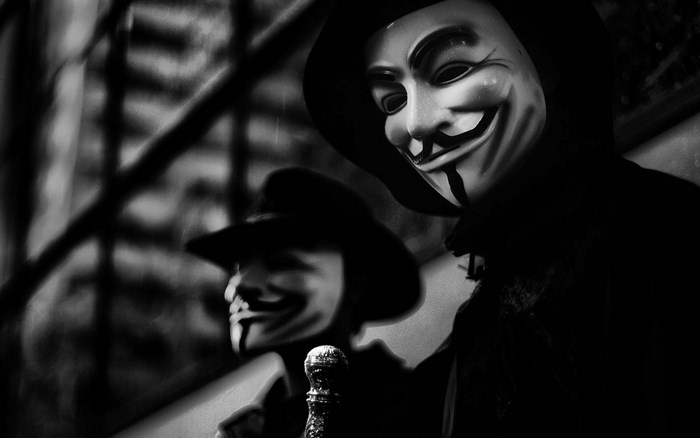 Two people wearing Guy Fawkes masks