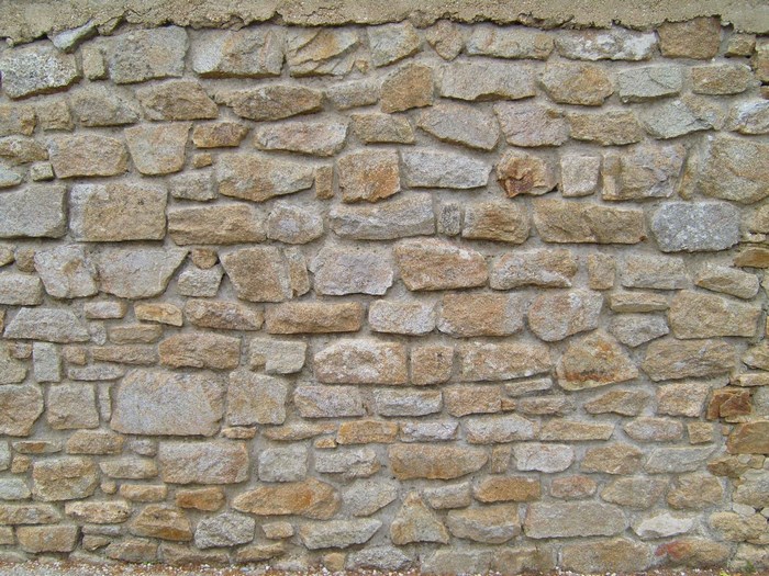 A textured wall made of rough, irregular stones.