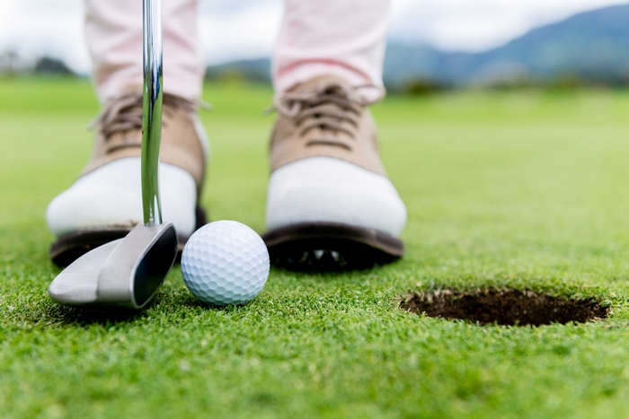 Golf ball and putter on a golf course