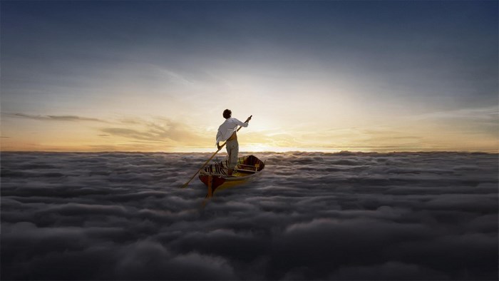 Man in a boat sailing on clouds