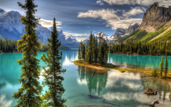 Turquoise lake with pine trees and snow-capped mountains