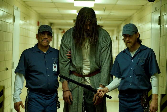 Three men in a hallway, two in staff uniforms