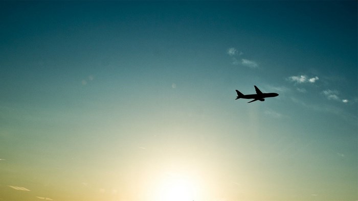 Airplane flying in the sky at sunset