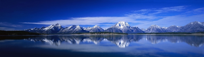 Snow-capped mountains reflected in a calm lake