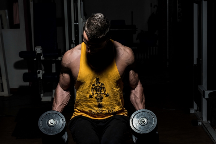 Bodybuilder lifting dumbbells in a gym