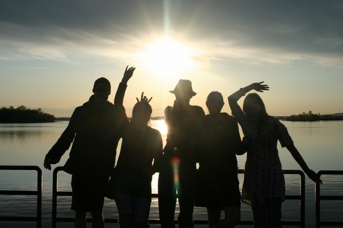 Group of friends silhouetted against the sun