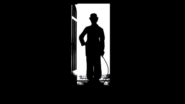 Silhouette of a man with a cane and bowler hat