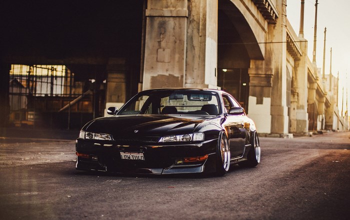 Black Nissan Silvia S14 parked under a bridge